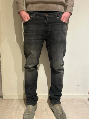 Mörkgrå jeans från Jack & Jones - Säljer ett par snygga mörkgrå jeans från jack & jones. Byxorna är knappast använda typ. Använda 2 gånger. Inga defekter modell tapered mike. Storlek 30/32