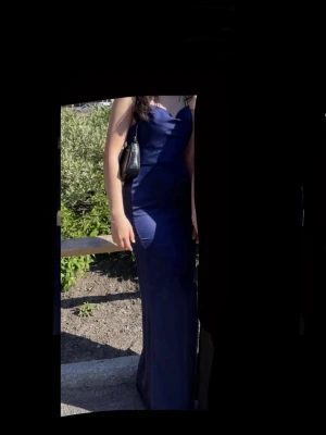 Marinblå långklänning från Nelly - Elegant marinblå långklänning från Nelly med figurnära passform. Perfekt för speciella tillfällen som bal, bröllop mm! Använd endast 2 gånger!