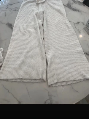 Vita oversized byxor  - Ribbstickade drömmar för hemmamys. Vida ben, mjuk känsla och en midja som alltid sitter skönt. Perfekt för lugna dagar och långsamma morgnar.