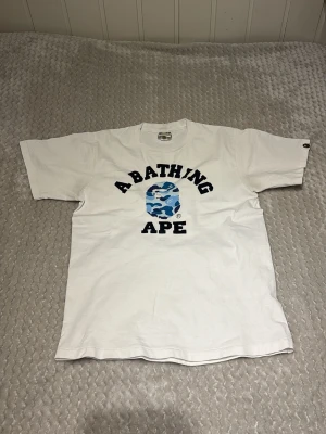 Vit Bape T-shirt - Säljer denna bape T-shirt pga den är för liten | Skick: 7/10 | Storlek: S | Köpt i en bape butik i New York! Fråga om ni vill veta något mer. Pris kan diskuteras vid snabb affär🤝
