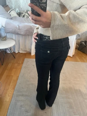 Svarta bootcut jeans ifrån true religon  - Säljer ett par svarta bootcut jeans ifrån true religon i modellen Joley Low Rise flare i storlek W27 anledningen till att jag säljer dem är för att dem är förstora för mig nu