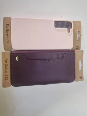 Två mobilskal  Samsung Galaxy S22 - Säljer två snygga mobilskal till Samsung Galaxy S22. Säljer de för billig pris båda dd tillsammans kostar 100 kr en är plånboksfodralskal en är en mobilskal