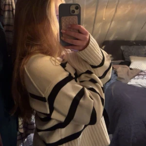 Vit stickad tröja med svarta ränder - Säljer en oversized stickad tröja i vitt med breda svarta ränder. Tröjan har långa ärmar med extra breda muddar och en klassisk rund halsringning. säljer pga används för sällan 💓