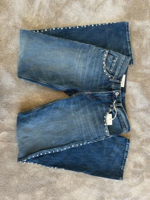 Blå jeans med pärldetaljer från Zara - Helt nya snygga blå jeans från Zara med raka ben och coola detaljer längs sidorna och fickorna. Aldrig använda med lappen kvar!