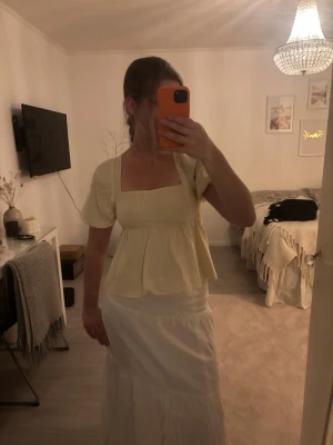 Gul blus med puffärmar och knyt - Superfin ljusgul blus med puffiga korta ärmar och söt knytning i ryggen. Blusen har en fyrkantig urringning och lätt volang nedtill som ger en romantisk vibe. Perfekt för varma dagar och ger en riktigt somrig känsla. (Kjolen säljer jag med)