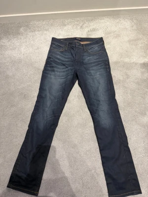 Mörkblå jeans från Jack n Jones - Snygga mörkblå jeans från Jack n Jones. Skick: nyskick endast prövade ett par gånger. Storlek 27x32. Mått står på bilderna. Hör av er vid frågor. Postar samma dag eller nästa dag 📦🚚 