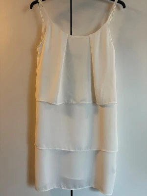 Vit klänning från Rut&Circle - Vit klänning från Rut&Circle. Klänningen har en lös passform och tunna axelband, vilket ger en luftig och somrig känsla. Materialet känns lätt och svalt, perfekt för varma dagar. Storlek 36.