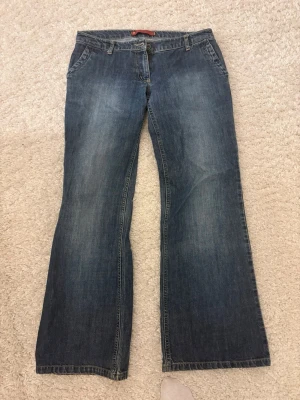 Mörkblå lågmidjade bootcut jeans - Snygga mörkblå bootcut jeans! Mått: Midja 37-38cm, Innerbenslängd 80-81cm