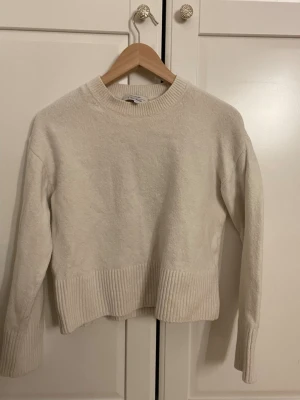 Vit stickad tröja från & Other Stories - Säljer en vit stickad tröja från & Other Stories Paris Atelier. Tröjan har rund hals, långa ärmar och bred ribbstickad kant vid ärmslut och nederkant.  enkel att matcha med allt. Köpt för 500kr inte nopprig jätte bra kvalité 