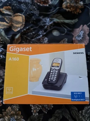 Siemens Gigaset A160 – Trådlös hemtelefon i fint skick med originalkartong - Säljer en pålitlig och användarvänlig trådlös telefon, modell Siemens Gigaset A160. Telefonen är fullt fungerande, i mycket gott skick och levereras i sin originalförpackning. Gigaset A160 är en trådlös telefon från Siemens. Den har en belyst display och nummerpresentation (CLIP). Telefonen har 10 ringmelodier och en telefonbok med plats för 40 poster. Den visar de 20 senaste missade samtalen. Standbytiden är upp till 200 timmar och samtalstiden är upp till 13 timmar.