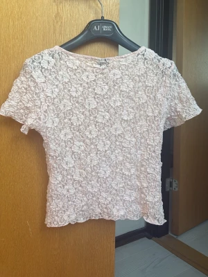 Ljusrosa spetsblus med blommönster💗 - Söt ljusrosa blus i spets med blommigt mönster och korta ärmar. I storlek S🫶🏼