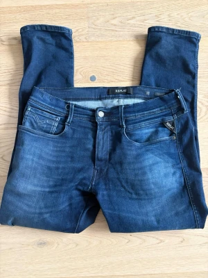 Replay anbass  - Snygga mörkblå jeans från Replay med klassisk femficksmodell Jeansen har raka ben och en liten logotypdetalj vid fickan. Perfekta för en avslappnad och trendig stil. Midja 33 och längd 30