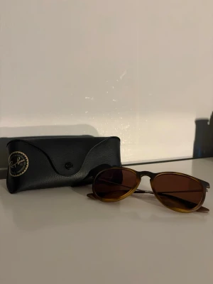 Bruna Ray-Ban solglasögon aviator - Snygga Ray-Ban solglasögon i klassisk aviator-modell med bruna glas och mörkbrun båge. Kommer med original svart fodral med Ray-Ban-logga. Perfekta för soliga dagar och ger en tidlös look.