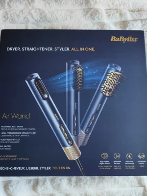BaByliss Air Wand hårstyler blå/guld - Ny i förpackning, aldrig använd. BaByliss Air Wand är en multifunktionell hårstyler i blått och guld som fungerar som hårfön, plattång och volymborste. Den har flera stylinghuvuden och avancerad teknik för att skydda håret mot värmeskador och minska friss. Perfekt för att skapa olika frisyrer hemma. 