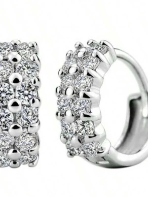 Prada silverfärgade örhängen med stenar - Säljer ett par exklusiva örhängen med gnistrande klara stenar i flera rader. Örhängena har en rundad form och ger ett lyxigt intryck med sin täta stenbesättning. Perfekta för dig som gillar statement-smycken och vill sticka ut.