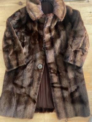 Pälskappa - Säljer min snygga och varma pälskappa, fin både vinter vpr och höst. Klassisk modell med bred krage, knappar framtill och helfoder i brunt tyg. Pälsen har ett naturligt mönster och ger en lyxig känsla. Perfekt för dig som vill hålla värmen med stil. Äkta päls, liten slitning bak syns knappt