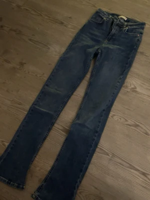 Mörkblå bootcut jeans från Gina Tricot - Snygga mörkblå bootcut jeans från Gina tricot. Jeansen har normal midja och är tillverkade i ett mjukt denimtyg som ger en skön passform. Perfekta för en avslappnad och trendig look. 