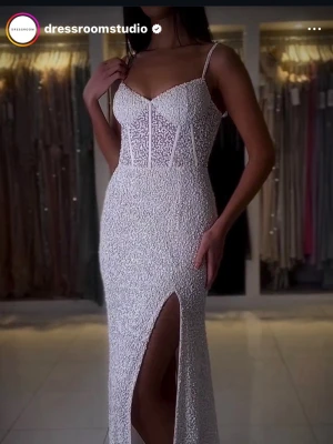 BALKLÄNNING SVART GLITTRIG - Svart balklänning från Dressroom Studio med svarta paljetter, smala axelband och markerad midja. Klänningen har en hög slits framtill och figurnära passform som ger en snygg siluett (går att justera med snören på baksidan, är en korsett). Perfekt för bal eller student. Säljer för 1200kr men pris går att diskutera. (nypris 3600kr)