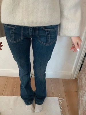 Mörkblå bootcut jeans med fickor - Snygga lågmidjade mörkblå bootcut jeans med fram- och bakfickor och kontrastsömmar