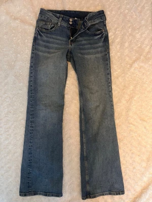 Low waisted jeans - Vintage blåa jeans med knappar bak från H&M, bra skick, storlek 36