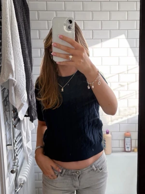 Mörkblå stickad topp  - Säljer en mörkblå stickad topp från AWARE/Vero Moda med korta ärmar och klassiskt kabelstickat mönster i storlek XS. Toppen har rund halsringning. Har använts 1 gång, nypris 449kr