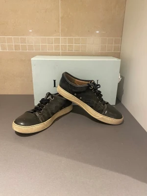 Svarta Lanvin sneakers i canvas och läder - Säljer ett par mörkgröna lantvins köpta från merchsweden. Säljer de pga att de blivit för små, säljer de billigt pga defektionerna på bild 3. Pris är ganska fast 😀