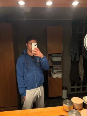 Blå Ed Hardy hoodie med dragkedja - Säljer en blå hoodie från trapper med dragkedja framtill och huva med. Och den har en mönster som en orm och sen stor de trapper, har inte fått den till användning så tycker att den passar hos nån annan bara att höra av sig vid frågor 