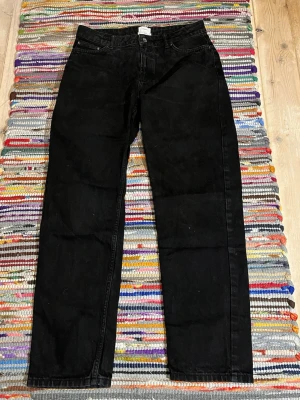 Svarta raka jeans i bomull - Säljer ett par sjukt feta svarta jeans från Grunt i storlek W29 och L31 med rak passform och klassisk femficksdesign. Jeansen är tillverkade i bomull och har en enkel, stilren look som passar till det mesta. Perfekta för dig som gillar en clean och tidlös stil.