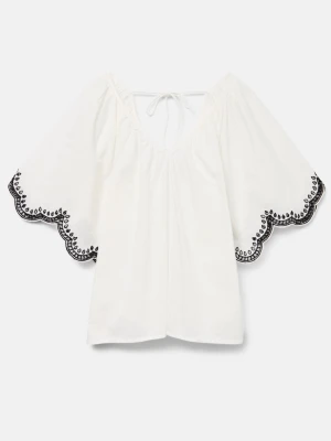 Vit blus med broderade kanter - Superfin vit blus med vida, korta ärmar och svarta broderade detaljer längs de vågiga kanterna. Blusen har v-ringning och knytning i nacken. Perfekt för en fräsch och somrig look.