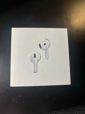 Apple AirPods 4 med brusreducering - Säljer ett par Apple AirPods 4 med brusreducering. Hörlurarna är vita, har en stilren och kompakt design i plast och levererar grymt ljud. Perfekta för musik, samtal och träning. Fick dubblett i julklapp och därav anledning för att jag säljer. Baksidan ser ut så för att de drog bort prislappen. Kvitto skickas vid förfrågan. Orginalpris 2400kr