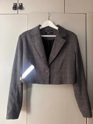 Grå rutig cropped kavaj Gina Tricot - Snygg grå cropped kavaj från Gina Tricot med rutigt mönster. Materialet är mjukt och den är väldigt snygg på! Använd ett fåtal gånger, storlek 38 🩶