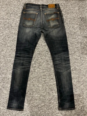Mörkblå Nudie jeans  - Riktigt feta Nudie jeans som har riktigt shyssta slitningar och fades, storlek W 30 och L32 