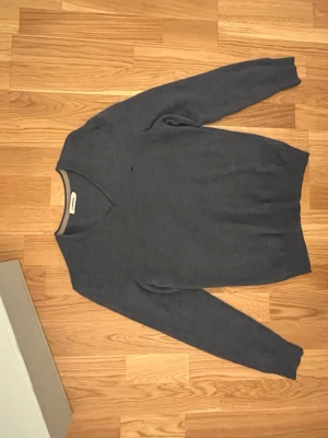 Baby blå tröja från j lindberg  - Baby blå stickad tröja med V-ringad hals och långa ärmar. Tröjan har en enkel och stilren design utan synliga mönster eller detaljer. Perfekt för lager på lager och passar till det mesta i garderoben. Priset går att diskuteras 