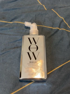 Color Wow Dream Coat spray 200ml - Rätt mycket kvar.Color Wow Dream Coat Supernatural Spray är en silvrig sprayflaska på 200 ml som används för att skydda håret mot fukt och ge glans. Flaskan har en modern, rektangulär form och spraymunstycke. Perfekt för dig som vill ha frizzfritt och glansigt hår.