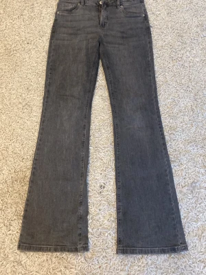 Grå bootcut jeans - Säljer ett par superfina grå jeans från Kappahl. De är bootcut och i strl 170. Lite slitet längst ner, men inget som syns när man använder de, annars är de superfina.