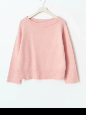 Ljusrosa oversized stickad tröja - Mysig ljusrosa stickad tröja med avslappnad passform och bred ribbad kant vid ärmslut och nederkant. Tröjan har en bred rund halsringning som kan bäras off-shoulder för en trendig look. Perfekt för lager på lager och chill stil.