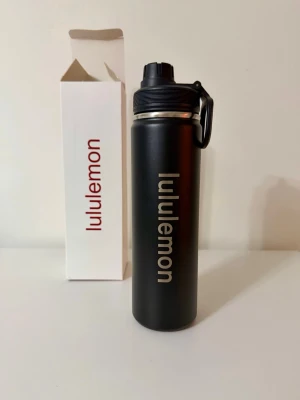 Svart vattenflaska Lululemon - Snygg svart vattenflaska från Lululemon i rostfritt stål med praktiskt lock och handtag