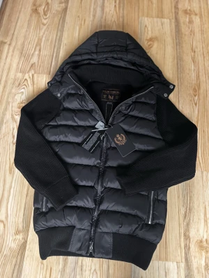 Leon Marcél Hybrid Jacket – Black | Detachable Hood - Premium hybrid jacket from Leon Marcél with detachable hood and microfleece-lined pockets. Top condition. Also available in all sizes at www.leonmarcel.co – pay with Klarna.