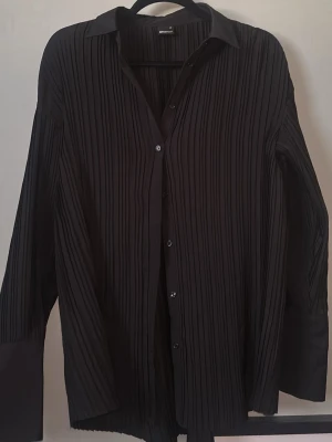 Svart plisserad kjol från Gina Tricot - Säljer en svart plisserad kjol från Gina Tricot i storlek 36. Kjolen har ett elegant fall och vertikala veck som ger en snygg struktur. Perfekt att styla med en enkel topp eller stickad tröja för en trendig look. 💕💕