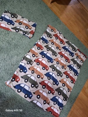 Påslakanset med bilar i flera färger - Säljer ett påslakanset med färgglada bilar i blått, grönt, rött och beige på vit botten. Setet består av ett påslakan och ett örngott, båda i mjukt tyg. Perfekt för dig som gillar roliga och lekfulla mönster till sovrummet.