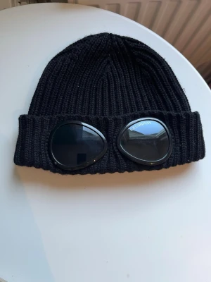 Svart mössa C.P. Company - Säljer en svart mössa från C.P. Company. Bra skick (som på bilderna) Självklart äkta. Pris kan diskuteras vid snabb affär!