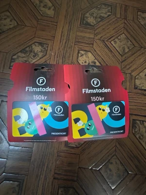 Filmstaden presentkort 150kr - Två presentkort från Filmstaden, värde 150kr styck. Kortet har en färgglad design med tecknade figurer och popcorn på framsidan. Perfekt för biobesök eller som present till någon som älskar film. Du får båda två för 200kr vid snabb affär. 