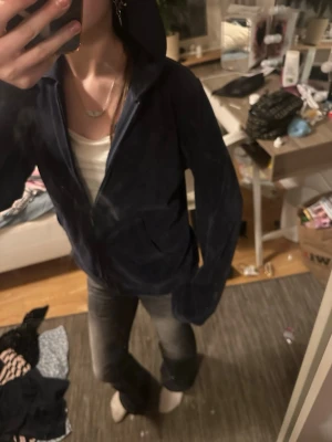 Mörkblå velour hoodie med dragkedja - Mysig mörkblå hoodie i mjuk velour med dragkedja framtill och stor huva. Har två fickor på magen och långa ärmar. Perfekt för en chill och avslappnad stil.