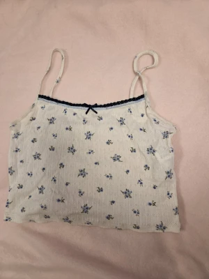 Blommigt linne med spetskant - Ett jättefint blommigt linne ifrån Pull & Bear! Det är croppat med svart spets längst upp och perfekt till sommaren! Det passar många olika stilar. Jag säljer då det tyvärr var för litet för mig och jag har aldrig använt det, bara provat men kunde inte lämna tillbaka det då jag tagit av lappen. Priset går såklart att diskutera!🥰