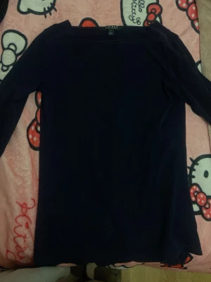 Mörkblå långärmad tröja Lauren - Mörkblå långärmad tröja från Lauren Ralph Lauren. Tröjan har en enkel, rak passform och dekorativa silverknappar med logga på ärmsluten. Perfekt till jeans eller kjol för en clean och stilren look.