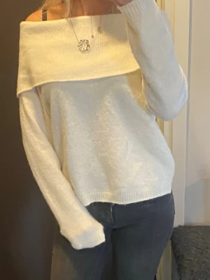Off shoulder vit stickad tröja Cubus - Säljer en vit stickad off shoulder-tröja från Cubus. Tröjan har bred krage som vilar över axlarna och långa ärmar. Rätt så stickig känsla, perfekt för att skapa en chill och trendig look. Ribbstickade detaljer vid krage, ärmslut och nederkant.