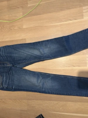 Blå smala jeans från Crocker - Säljer ett par blå jeans från Crocker med smal passform och klassisk femficksdesign. Jeansen har snygga slitningar och kontrastsömmar, tillverkade i stretchigt bomullsmaterial för extra komfort. Perfekta till vardagslooken! 30:32