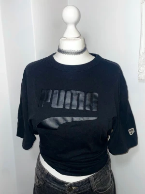 Svart PUMA t-shirt - Svart oversized t-shirt från PUMA med stor blank logga framtill. T-shirten har rund halsringning och korta ärmar. 100% Bomull. Tror att den är från mansavdelningen. Knappt använd.