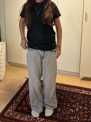 Vida ljusgrå jeans från Divided - Säljer ett par ljusgrå, vida jeans från Divided. Jeansen har en avslappnad passform med raka ben och klassiska fem fickor. Perfekta för en chill och trendig look. Materialet är denim i bomull och färgen är snyggt tvättad ljusgrå.