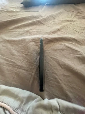 Svart iPhone men Behöver vänta tror tolv år - Säljer en svart iPhone med platt ram i metall och klassisk stilren design. Telefonen har tydliga volymknappar på sidan och en smal profil som känns modern och enkel att hålla i handen. Perfekt för dig som gillar Apples ikoniska look.